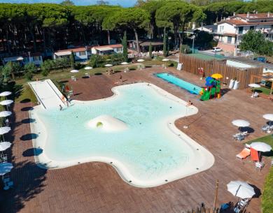 Piscina all'aperto con scivoli, ombrelloni e area giochi per bambini.