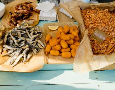 Variété de poissons frits et croquettes sur papier sulfurisé.