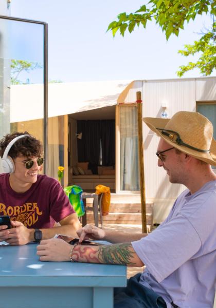 Two people sitting at an outdoor table, chatting and relaxing.