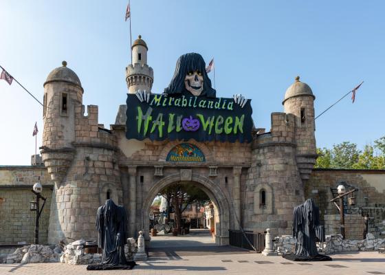 Entrance of Mirabilandia decorated for Halloween with castle and ghostly figures.