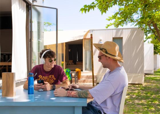 Two people sitting at an outdoor table, chatting and relaxing.