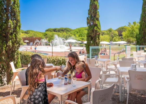 Famiglia si gode una bevanda all'aperto vicino alla piscina.